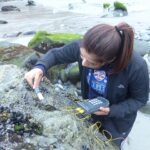 Student Alexis Barrera collects algae samples